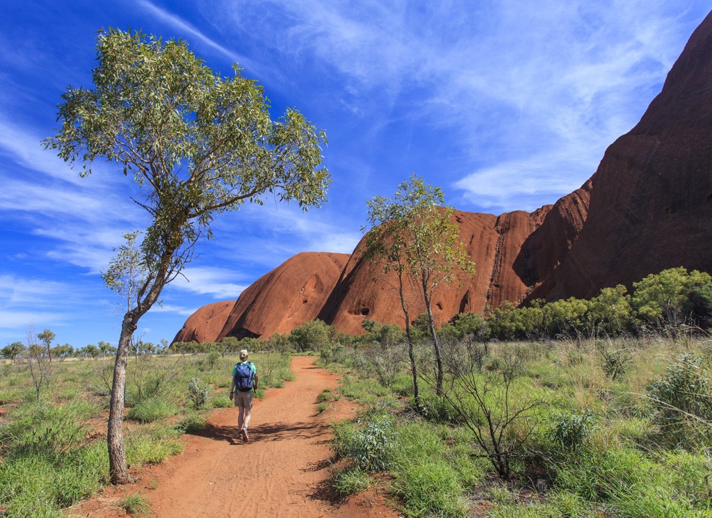 Wandelaar op het pad bij Uluru (Ayers Rock) tijdens rondreis Australië kampeer- en hotelreis.