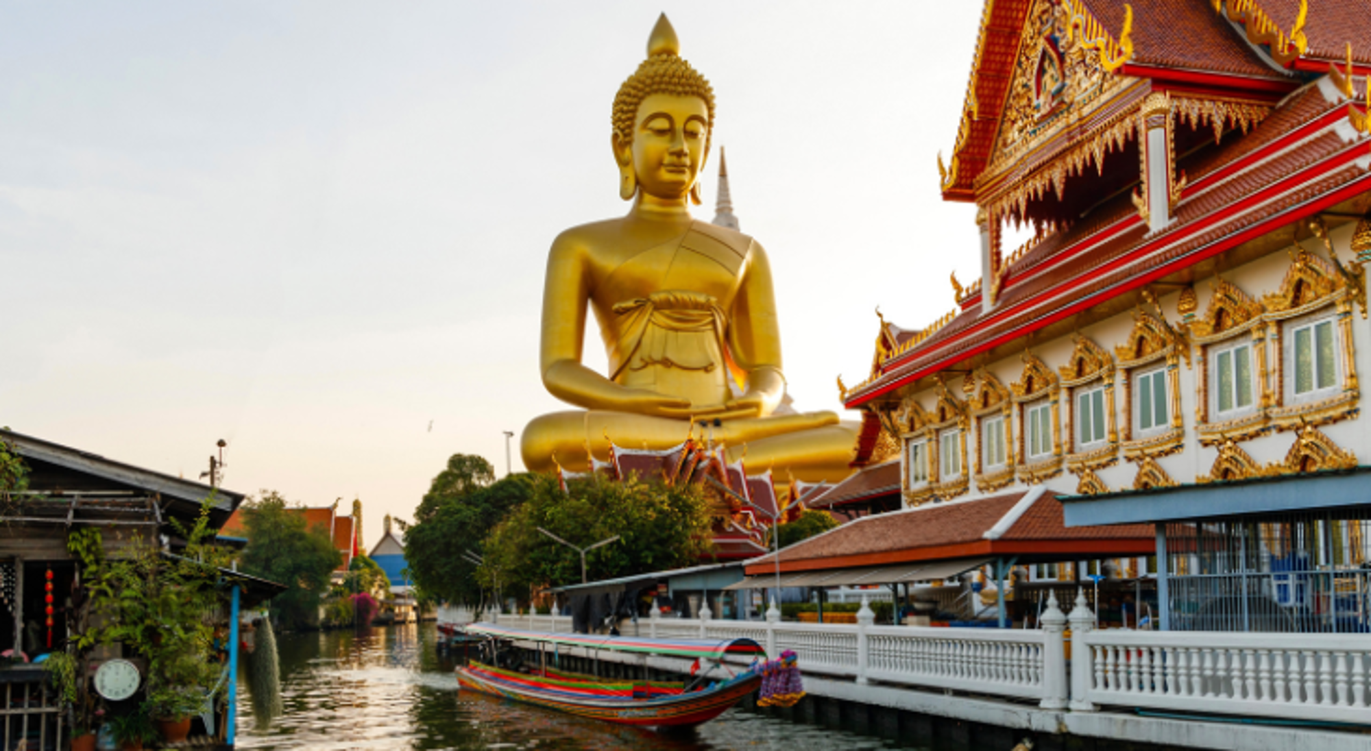 Golden Temple Sri Lanka Grote gouden Boeddha bij Wat Paknam, met tempelgebouw en boot op het kanaal in Bangkok, Thailand.