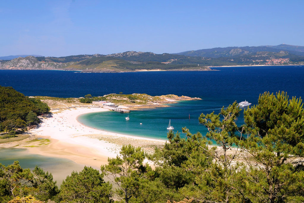 Uitzicht op een baai met wit zandstrand en turquoise water aan de kust van Spanje, tijdens familiereis Spanje & Portugal.