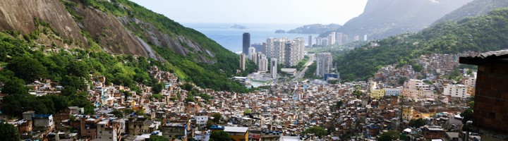 Uitzicht over Rocinha in Rio de Janeiro, met dichtbebouwde wijk op de heuvel en de kustlijn op de achtergrond.