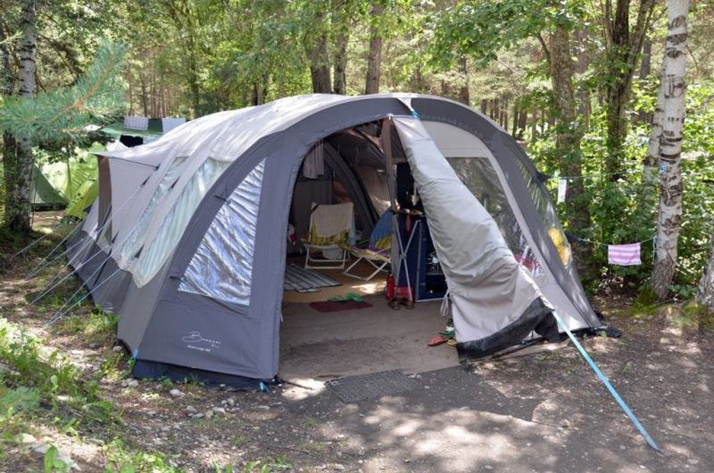 Tent op een camping in het Écrins-gebied in Frankrijk, omringd door bergen en bomen.