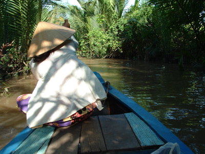 Boottocht door de Mekongdelta in Vietnam langs smalle kanalen met palmen.