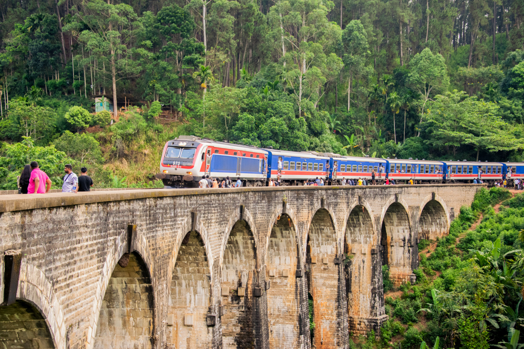 Trein op de Nine Arch Bridge in Sri Lanka, omringd door groen, tijdens een 22-35ers groepsrondreis.