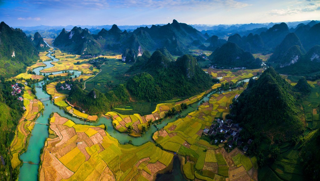 Karstbergen en rijstvelden langs een kronkelende rivier tijdens een groepsrondreis China & Vietnam.