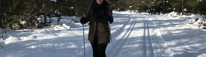 Carolien, coördinator duurzaamheid bij Sawadee, langlaufend op een besneeuwde bospad.