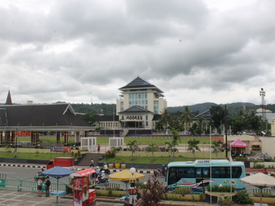 Kantoorgebouw van de gouverneur van de Molukken in Ambon, met bus en verkeer op de voorgrond.