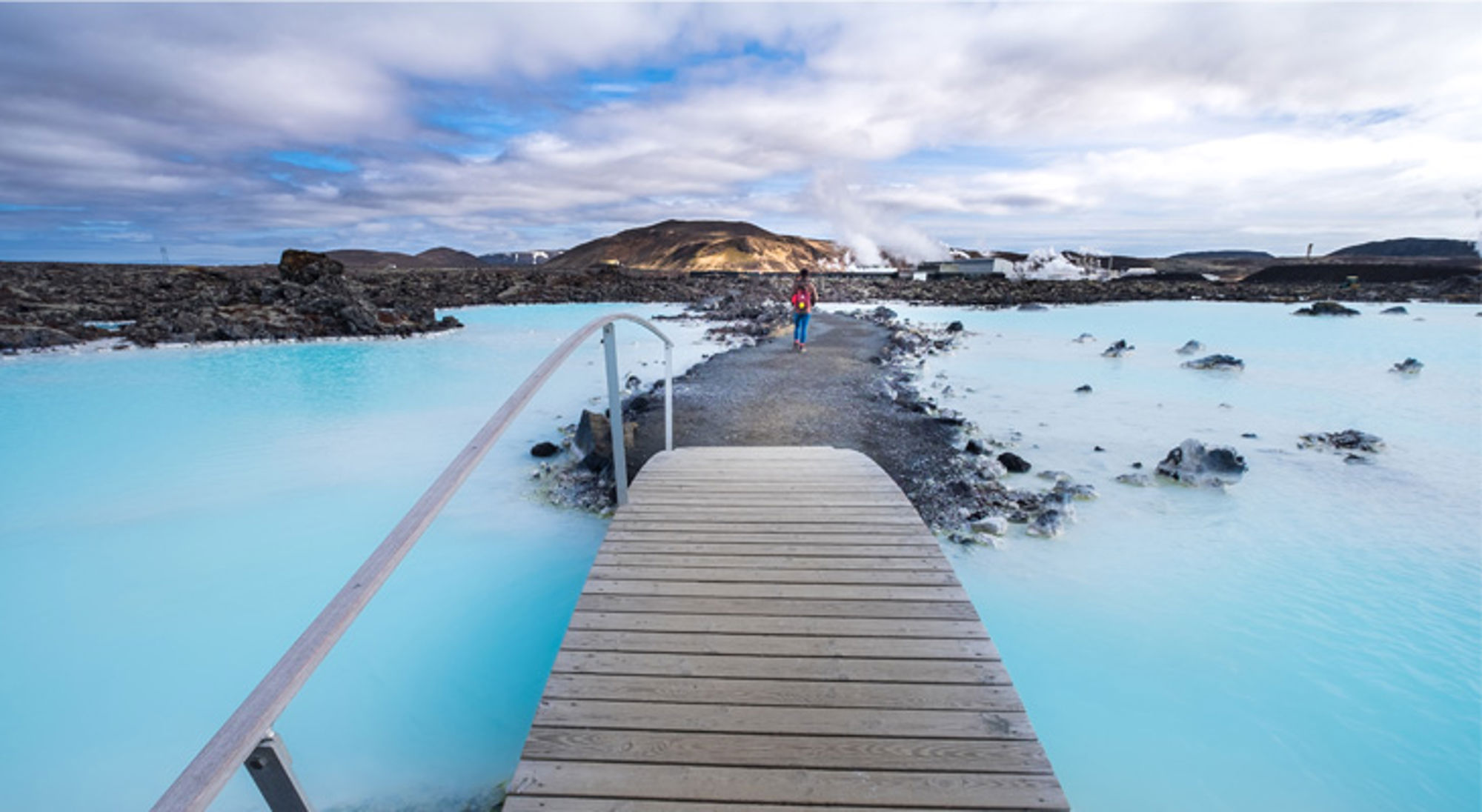 Blue Lagoon geothermal Houten loopbrug naar de Blue Lagoon met helderblauw geothermisch water in IJsland.