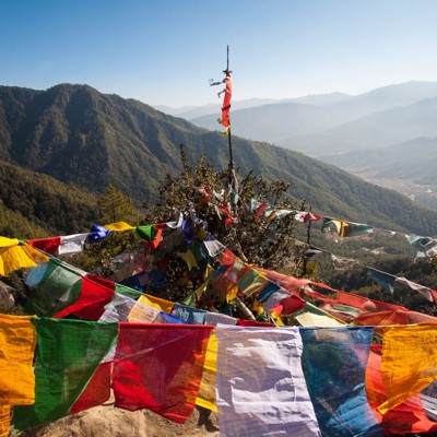Gekleurde gebedsvlaggen met uitzicht op de Himalaya in Bhutan tijdens groepsrondreis Sikkim en Bhutan.