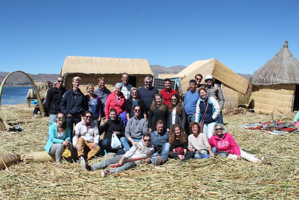 Groepsfoto van reizigers op de rieteilanden van het Titicacameer in Peru, tijdens groepsrondreis Peru Hoogtepunten.