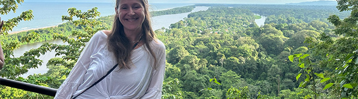 Tessa bij een uitkijkpunt met uitzicht op het regenwoud en de kust van Costa Rica.