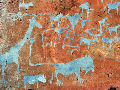 Rotstekening met dierenfiguren, waaronder giraffe, neushoorn en antilopes, op een roodbruine rotswand.