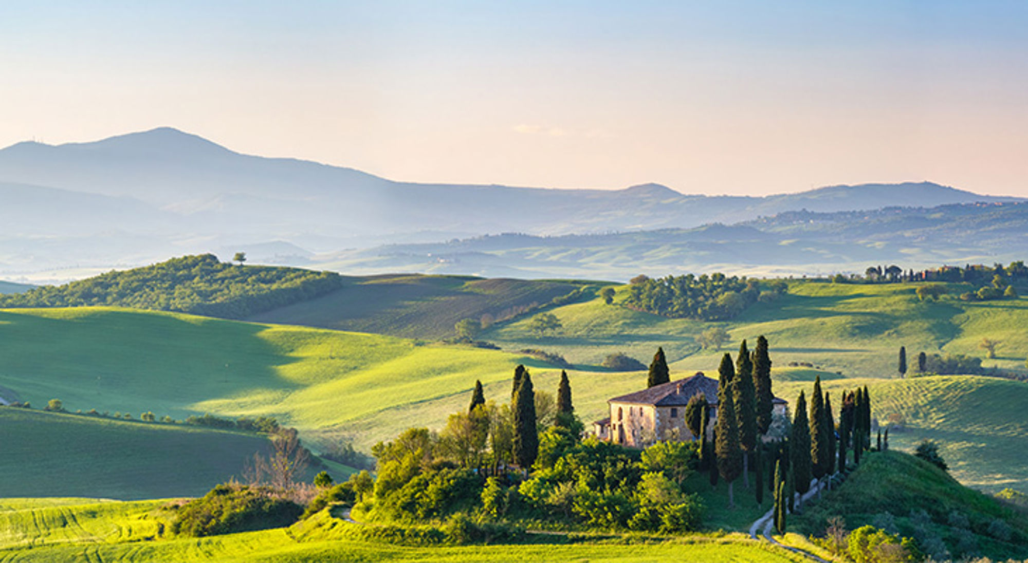 Toscane Heuvelachtig Toscane-landschap met cipressen en landhuis in de ochtendzon.