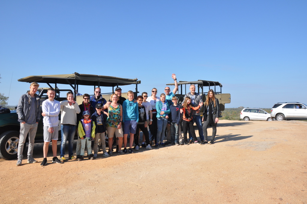 Groep reizigers bij safariwagens tijdens familiereis Zuid-Afrika, Tuinroute en Kruger.