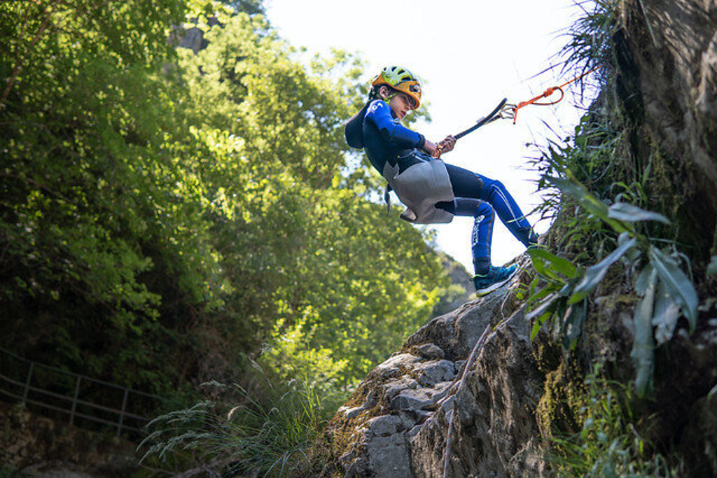Kind abseilt langs rotswand tijdens canyoning bij de Rio Cinca in Aragon, Spanje.