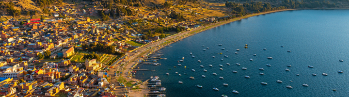 Uitzicht op het Titicacameer bij Copacabana in Bolivia, met de baai vol bootjes en bergen op de achtergrond.