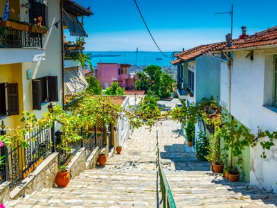 Steeg met trappen en huizen in Thessaloniki, met uitzicht op de baai van Thermaikos in Noord-Griekenland.