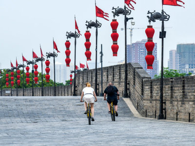 Fietsers op de stadsmuur van Xi’an, versierd met rode Chinese lantaarns.