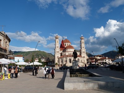 Plein in Korçë met de Orthodoxe Opstandingskathedraal en Albanese vlag, Route Albanië.