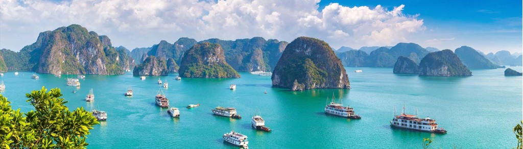 Cruiseboten tussen kalkstenen rotsen in Halong Bay, Vietnam.