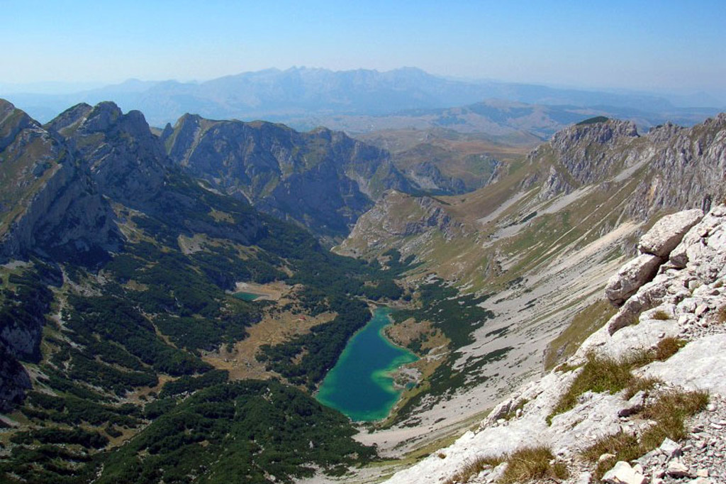Uitzicht op berglandschap met turquoise bergmeer in Montenegro tijdens een wandelvakantie.