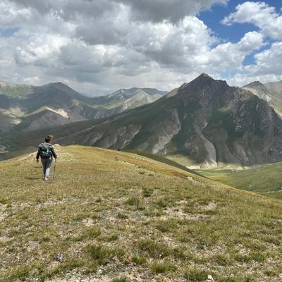 Groepsrondreis Kirgistan: wandelaar met rugzak in berglandschap langs de Zijderoute.