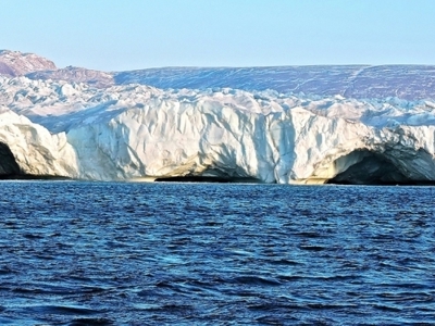 Gletsjerwand met ijsgrotten aan de kust van Groenland, gezien vanaf zee.