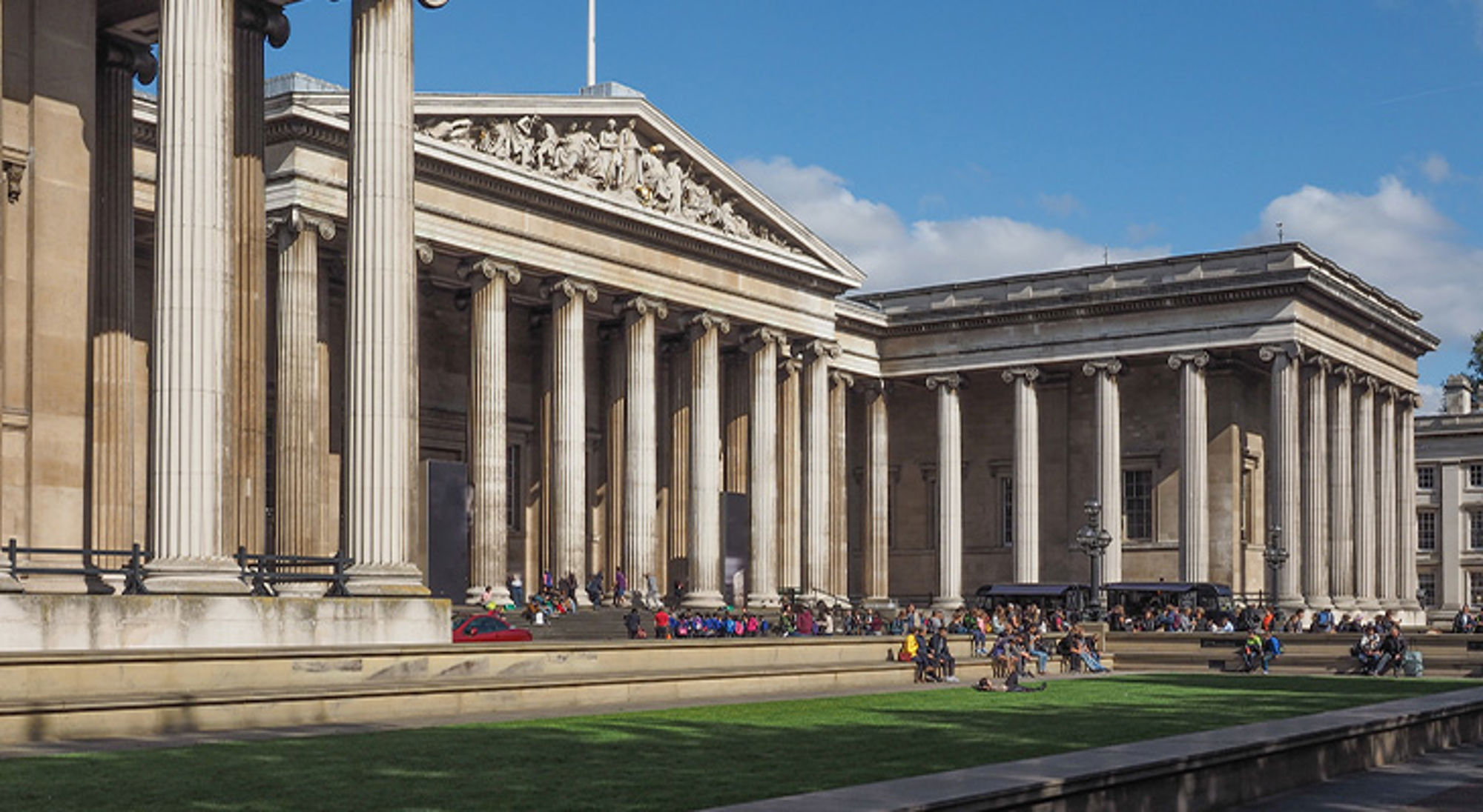 British Museum, Londen Neoklassiek gebouw met hoge zuilen en bezoekers op het plein bij het British Museum in Londen.