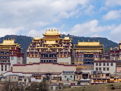 Songzanlin-klooster bij Shangri-La in Yunnan, China, met gouden daken tegen een berglandschap.