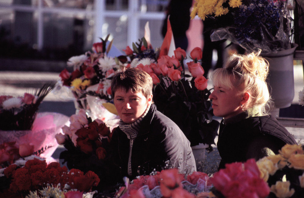 Twee vrouwen bij een bloemenkraam met kleurrijke boeketten tijdens een groepsrondreis door Rusland.