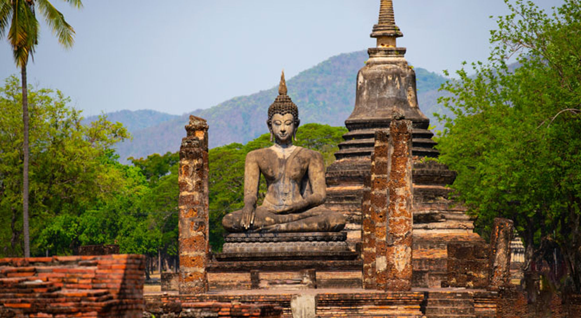 Buddha Sukhothai Boeddhabeeld bij oude tempelruïnes in Sukhothai Historical Park, Thailand.