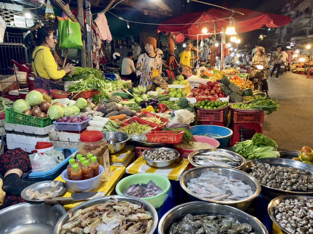 Drukke avondmarkt met groente, fruit en verse vis bij kraampjes tijdens de 22-35ers reis Thailand, Laos & Cambodja.