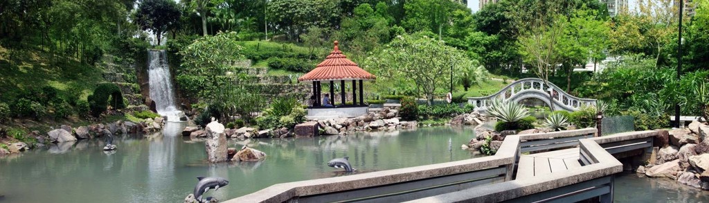 Groene Japanse tuin met vijver, waterval, paviljoen en boogbrug tijdens groepsrondreis Japan hoogtepunten.