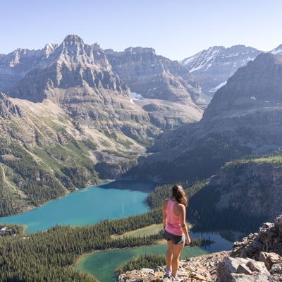 Wandelaar met uitzicht op turquoise bergmeer en ruige Rocky Mountains in West-Canada.