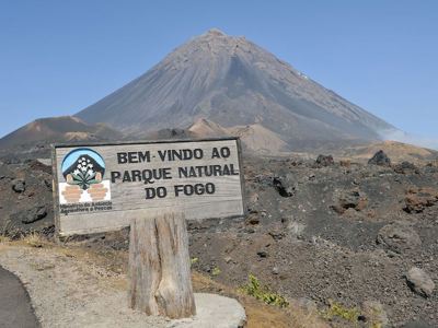 Welkomstbord van Parque Natural do Fogo met de vulkaan Pico do Fogo op Kaapverdië op de achtergrond.