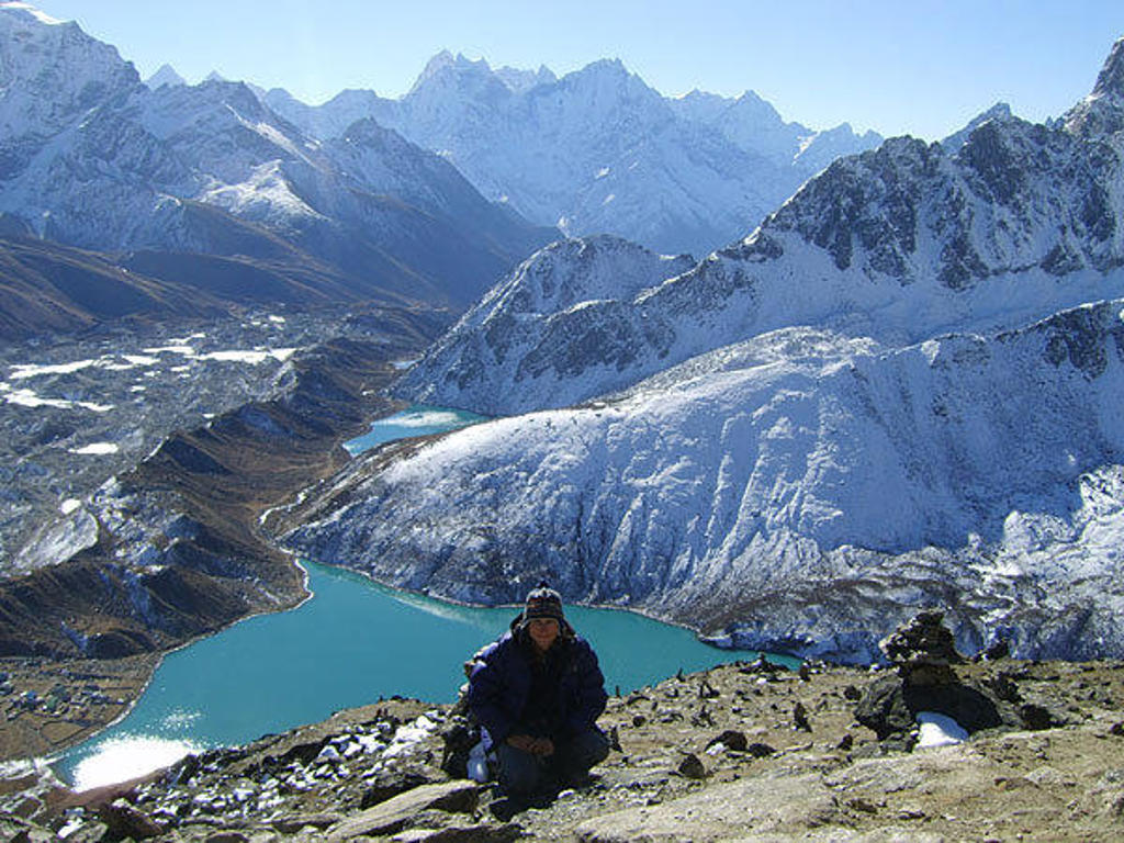 Uitzicht op besneeuwde Himalaya-toppen en turquoise bergmeer tijdens de Nepal Everest-trektocht.