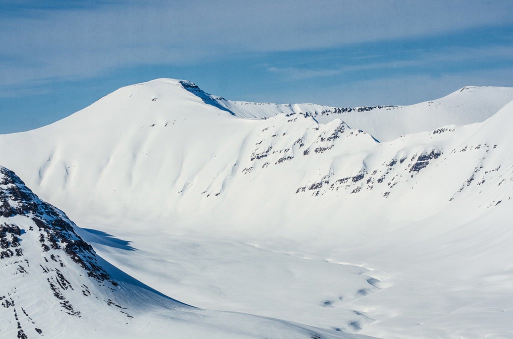 Sneeuwbedekte bergen in Noord-IJsland onder een heldere blauwe lucht.