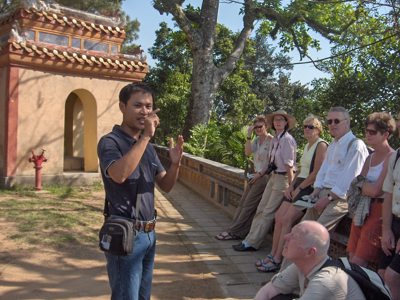 Gids geeft uitleg aan reisgroep bij een tempelcomplex tijdens de Route Vietnam.