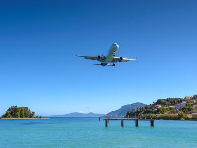Vliegtuig in landing boven de kust bij Corfu, startpunt van de Route Zuidoost Europa.