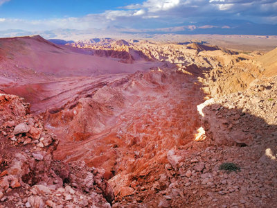Uitzicht over de Valle de la Luna met rode rotsformaties en bergen in de verte in Chili.