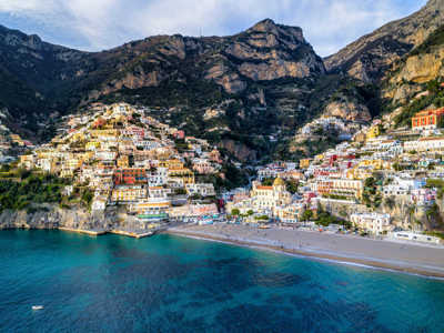 Kleurrijke kustplaats Positano aan de Amalfikust, met huizen tegen de steile rotsen en strand aan zee.