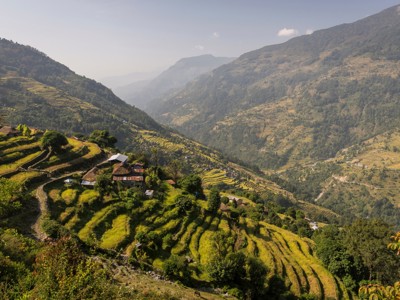 Terrasvormige rijstvelden en dorpje in de heuvels langs de Route Nepal Annapurna.