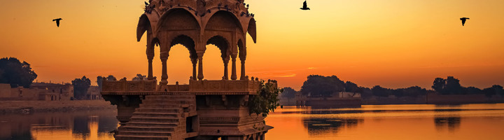 Zonsondergang bij een cenotaaf aan het Gadisar-meer in Jaisalmer, Rajasthan.