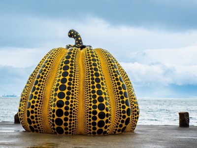 Gele pompoenkunstwerk met zwarte stippen aan zee op Naoshima, Route Japan dag 12.
