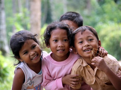 Vrolijke kinderen poseren samen in de natuur tijdens de Route Java en Bali-reis.
