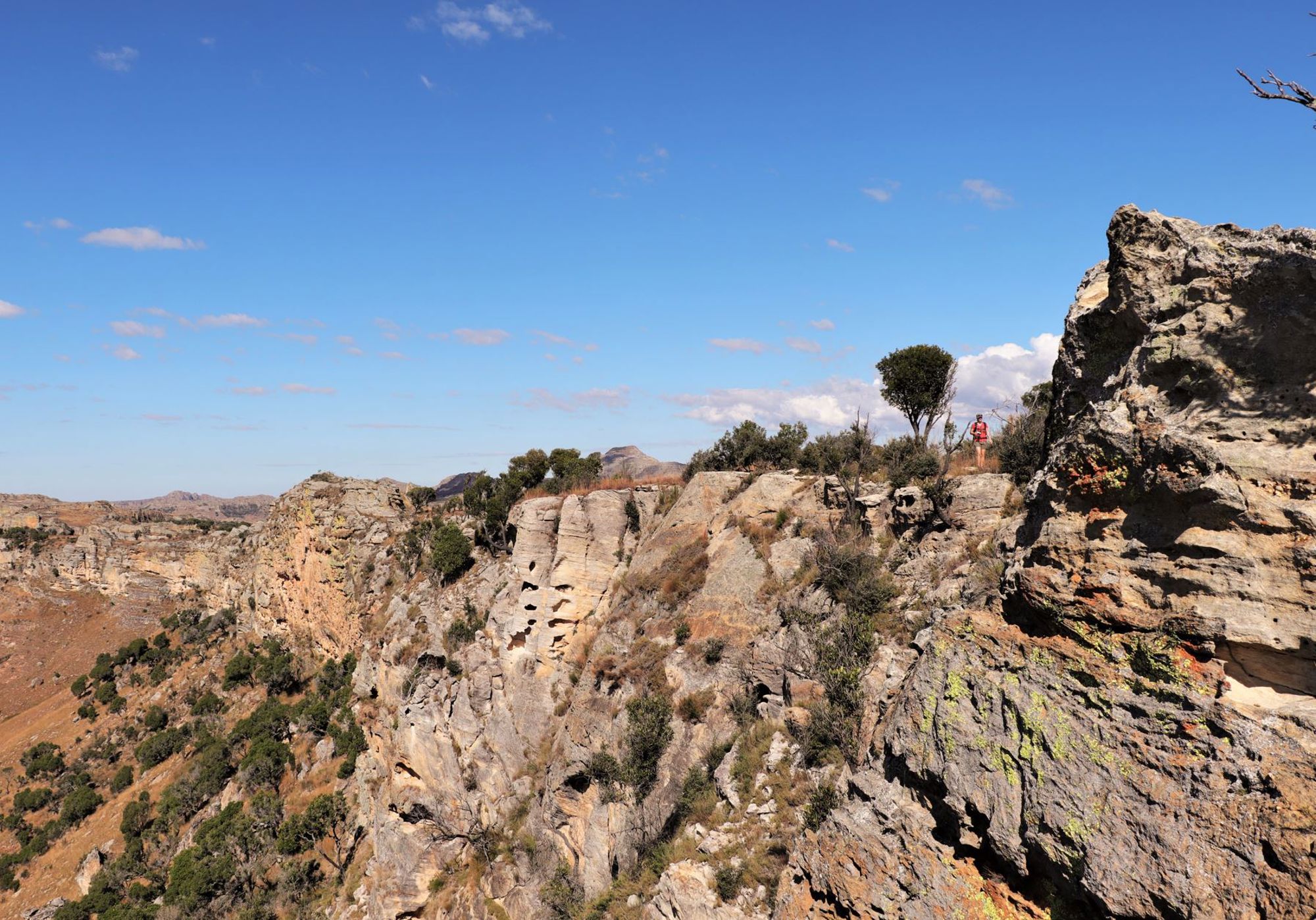 Rotsachtige kliffen en canyons in het ruige landschap van Madagascar onder een heldere blauwe lucht.