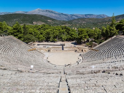 Oud amfitheater van Epidaurus met stenen tribunes en uitzicht op groene heuvels, Route Griekenland meivakantie.
