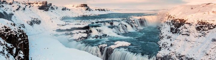 Panoramisch uitzicht op besneeuwde bergen en een fjord in IJsland.