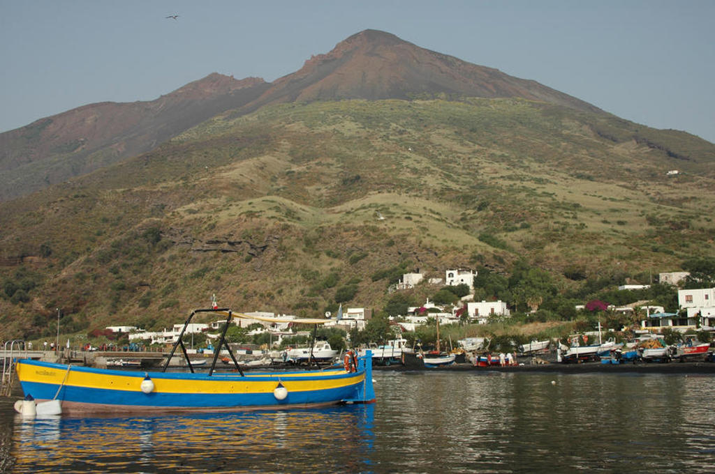Vissersboot in de haven met berglandschap op de achtergrond, West Sicilië, Italië.