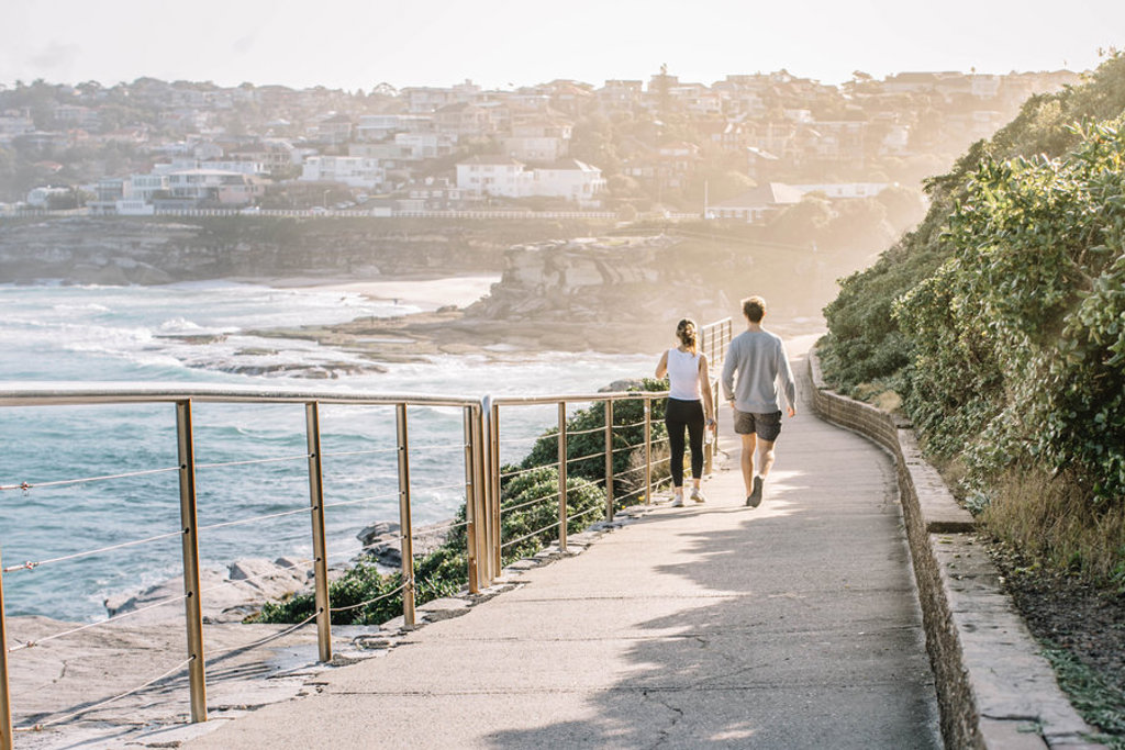 Wandelaars op de kustboulevard in Sydney tijdens een 22-35ers reis door Australië.