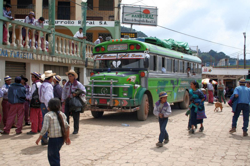 Groene chickenbus op een druk plein in Guatemala, tijdens een groepsrondreis richting Copán.